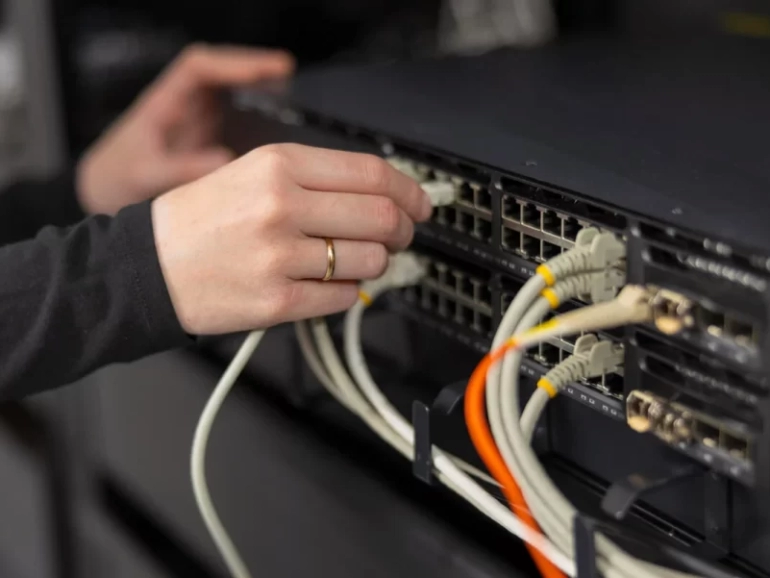female-it-technician-in-a-datacenter-connecting-an-2025-11-13-23-03-37-utc